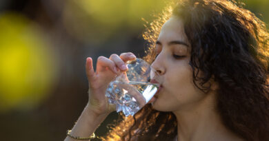 Girl drinking water from glass in park